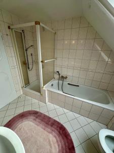 a bathroom with a tub and a shower and a sink at Südblick 1 in Fehmarn +22 photos