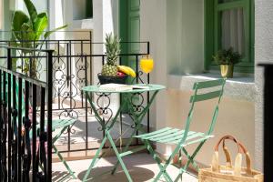 a table and a chair on a balcony with a drink at Aurelia Boutique - Suites in Rhodes Town