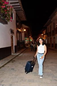 a woman walking down a street with a suitcase at Casa Hospedaje Teresita in Chachapoyas