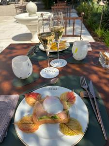 a table with a plate of food and glasses of wine at Relais Villa Alma in Castion Veronese