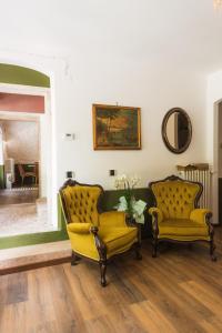 a living room with two yellow chairs and a mirror at Relais Villa Alma in Castion Veronese +28 photos