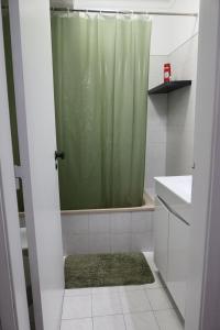 a bathroom with a shower with a green shower curtain at Apart Lisbon Airport in Lisbon