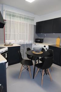 a kitchen with a table and two chairs in it at Apart Lisbon Airport in Lisbon
