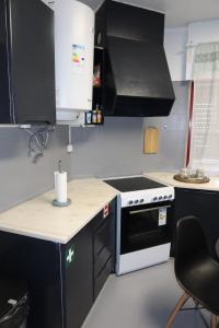 a kitchen with black cabinets and a white stove top oven at Apart Lisbon Airport in Lisbon +11 photos
