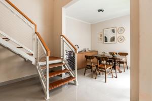 a kitchen and dining room with stairs and a table at Sakabumi Home in Ngabean