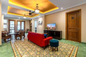 a living room with a red couch and a dining room at Sakabumi Home in Ngabean