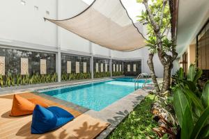 an indoor swimming pool with blue and orange pillows at Sakabumi Home in Ngabean