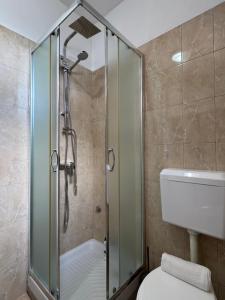 a bathroom with a shower and a toilet at Blessed guest house in Shkodër