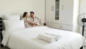 a man and a woman sitting on a bed at Mom's House Floralia in Cali