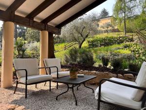 a patio with chairs and a table and a garden at Relais Villa Alma in Castion Veronese
