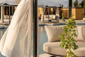 ein weißes Sofa neben einem Swimmingpool in der Unterkunft Das Stemp Wellnessresort 4 Sterne Superior in Büchlberg