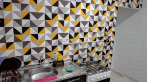 a kitchen with a sink and a geometric tile wall at Yellowkits in São Paulo +21 photos