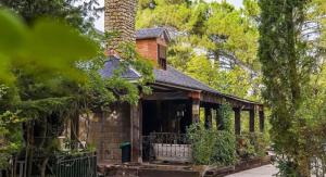 a house in the woods with a chimney at Hotel Rural Victoria by Bossh! Hotels in Cuenca