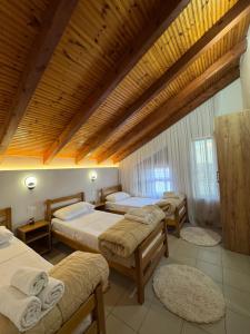 a bedroom with three beds and a wooden ceiling at Blessed guest house in Shkodër +30 photos