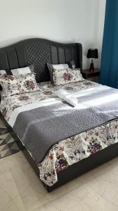 a bed with a black frame with flowers on it at Condominio hortencia in Viana