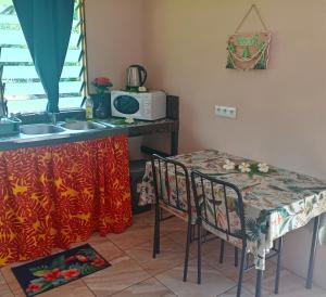 a kitchen with a table and two chairs and a sink at Hitimahana lodge in Fare