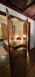 a room with a bed and a door with a mirror at Tapioca Vila Boutique in Atins +49 photos