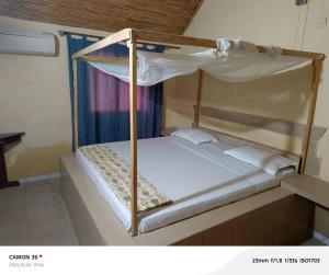 a bunk bed in a room with a white bed at A La Teranga in Poundiougne