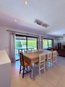 a kitchen and dining room with a table and chairs at Casa con piscina en Estancias del Pilar, 3 dormitorios, jardín y parrilla in Pilar