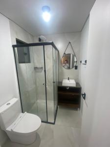 a bathroom with a shower and a toilet and a sink at Pousada Vale das Bromelias Termas do Gravatal in Gravatal
