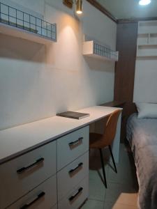 a kitchen with a desk and a bed in a room at Premier Cabins in North Legon