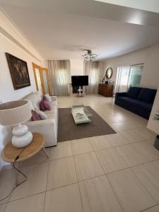 a living room with a couch and a table at Pool, BBQ & Soccer Villa in Aroeira