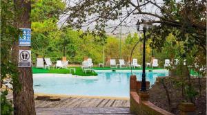a swimming pool with chairs and chairs in a yard at Hotel Rural Victoria by Bossh! Hotels in Cuenca