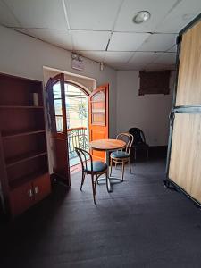 a room with a table and chairs and a door at Eva hostel & chill Ayacucho in Ayacucho