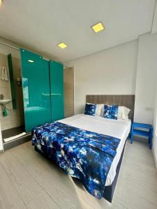 a bedroom with a large bed with blue sheets at Agora Suites Hotel, Check-in digital fácil con atención virtual 24h in Bogotá +29 photos