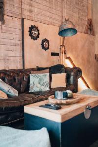 a living room with a couch and a coffee table at Le Loft "L'Atelier", petit déj inclus in Fauvillers