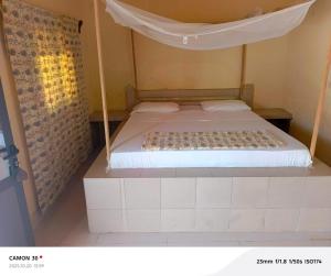 a bedroom with a bed with a canopy at A La Teranga in Poundiougne