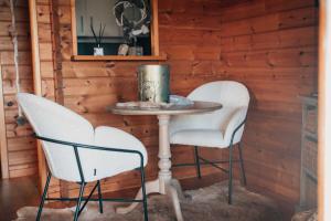 two chairs and a table in a room at Chalet d'hôtes - Les Daims - Petit déjeuner inclus in Fauvillers