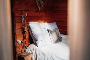 a bedroom with a bed with white sheets and pillows at Chalet d'hôtes - Les Daims - Petit déjeuner inclus in Fauvillers