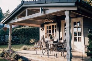 a patio with a table and chairs under awning at Chalet d'hôtes - Les Daims - Petit déjeuner inclus in Fauvillers
