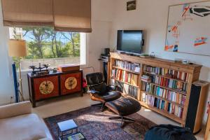 a living room with a chair and a television at la villa avezard in Blonville-sur-Mer