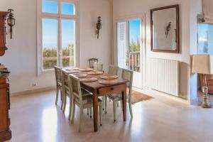 a dining room with a wooden table and chairs at la villa avezard in Blonville-sur-Mer