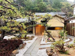 a japanese garden with a house and trees at 宮島 Shinwa in Miyajima