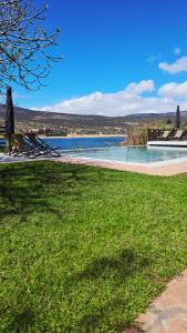 a beach with chairs and a body of water at Le Figuier du Lac Bin elouidane in Bine el Ouidane