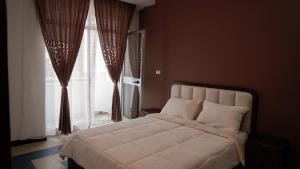 a bedroom with a large bed and a window at Sheba Palace Apartment in Addis Ababa