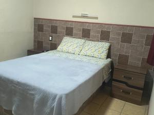 a bedroom with a bed with a pillow and a nightstand at Servicios de Hospedaje in Orizaba +4 photos