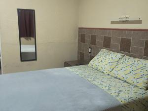 a bedroom with a bed with a blue and yellow pillow at Servicios de Hospedaje in Orizaba