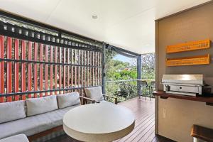 a living room with a couch and a table at At Melaleuca 1 in Point Lookout