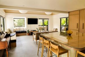 a kitchen with a bar and a living room at Matakana Retreat - Luxury Off Grid Lodge in Nature in Matakana