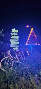 a bike parked next to a street sign at night at Chalé Suíço com Jacuzzi in Marechal Floriano