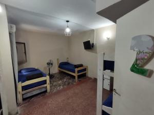 a room with two bunk beds and a tv at Como en casa Hostel in Posadas