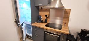 a kitchen with a counter with a sink and a stove at Le Petit Jaune in Orthez +2 photos