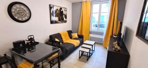 a living room with a couch and a table at Le Petit Jaune in Orthez