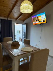 a dining room table with chairs and a television on the wall at merlomar1 in Merlo