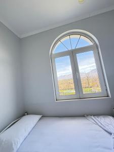 a white room with a window and a bed at Hotel corner in Bërzhitë