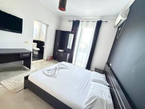 a bedroom with a bed and a sink and a television at Hotel corner in Bërzhitë +11 photos